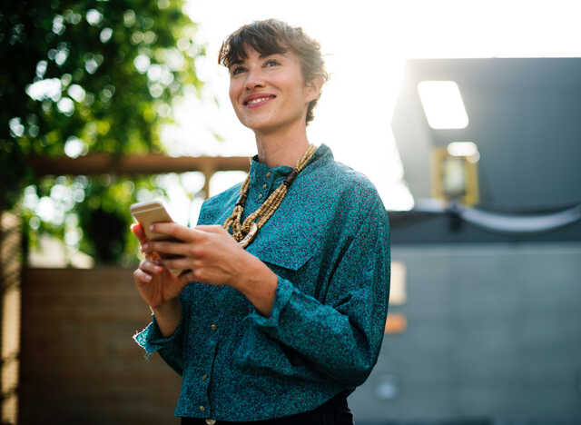 woman smiling holding her phone